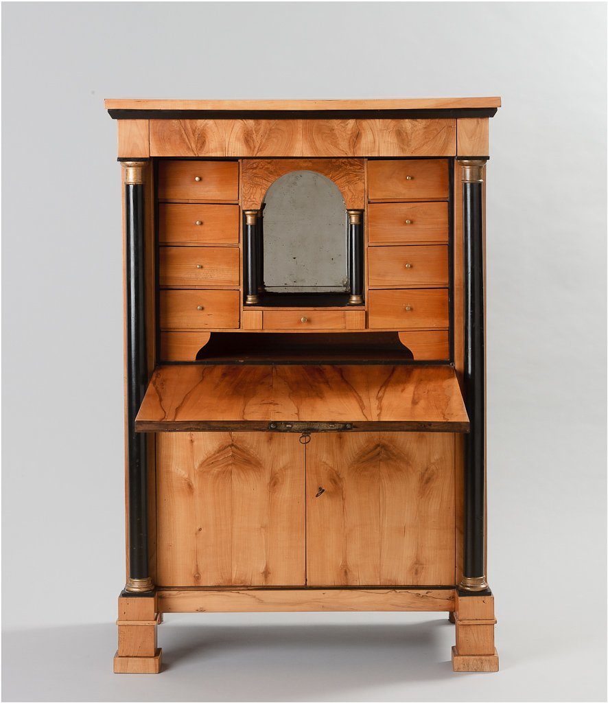 BIEDERMEIER-SEKRETÄR: BIEDERMEIER-SEKRETÄR Kirsche, furniert und teils ebonisiert. Über zwei Türen aufklappbare Schreibplatte, flankiert von zwei Säulen. Part. besch., rest., obere Platte ergänzt, H. 151 cm, B. 102,5 