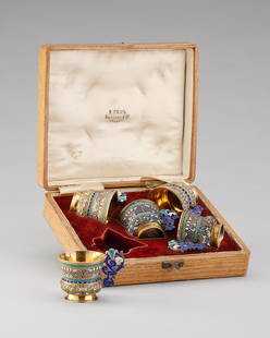 FEINES CLOISONNÉ-EMAIL-WODKASET IM ORIGINALETUI: FEINES CLOISONNÉ-EMAIL-WODKASET IM ORIGINALETUI Silber, vergoldet. Bestehend aus sechs Tscharki. Auf der gebauchten Wandung und dem konisch ausgestellten Rand umlaufende Friese in blauem, rotem, wei�