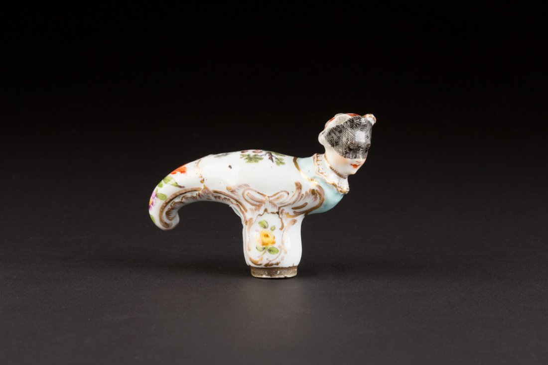 STOCKKNAUF MIT FRAUENKOPFZIER Deutsch, wohl KPM-Berlin,: STOCKKNAUF MIT FRAUENKOPFZIER Deutsch, wohl KPM-Berlin, 2. Hälfte 18. Jh. Porzellan, polychrome Blumenmalerei und Goldstaffage, auf dem Griff Darstellung eines Paares im Park, plastisch ausgearbeitet
