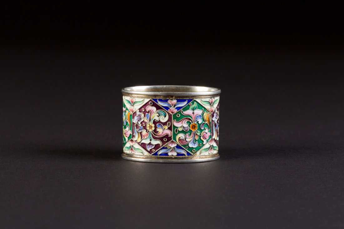 JUGENDSTIL-CLOISONNÃ‰-EMAIL-SERVIETTENRIN G: A SILVER-GILT AND CLOISONNÃ‰ ENAMEL NAPKIN RING Russian, Moscow, 1908-1917 Of oval section, with floral ornament on a green and purple ground. Marked with assayer's mark, 84 standard and master's m