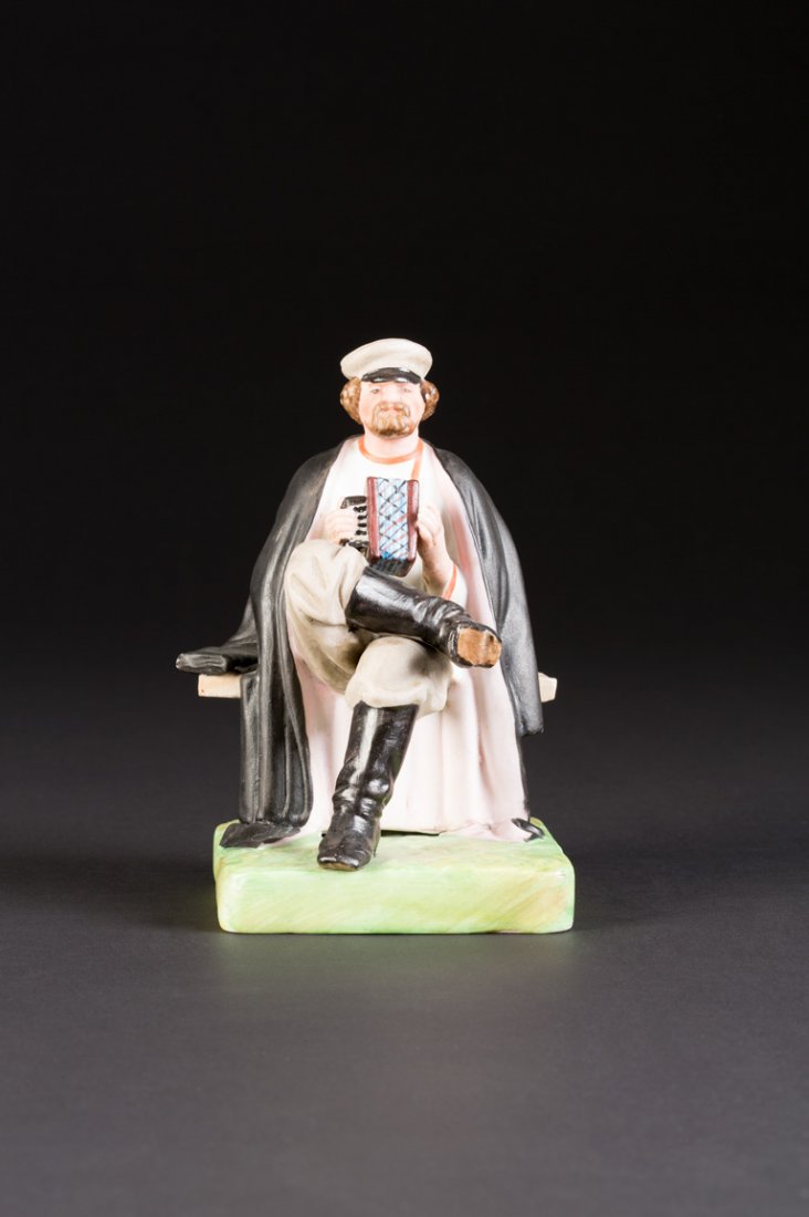 AKKORDEON-SPIELER: A BISCUIT PORCELAIN FIGURE OF AN ACCORDIAN PLAYER Russian, Verbilki, Gardner Manufactory, late 19th century On a square base with naturalistic ground. Realistically modelled in grey coat. Marked under