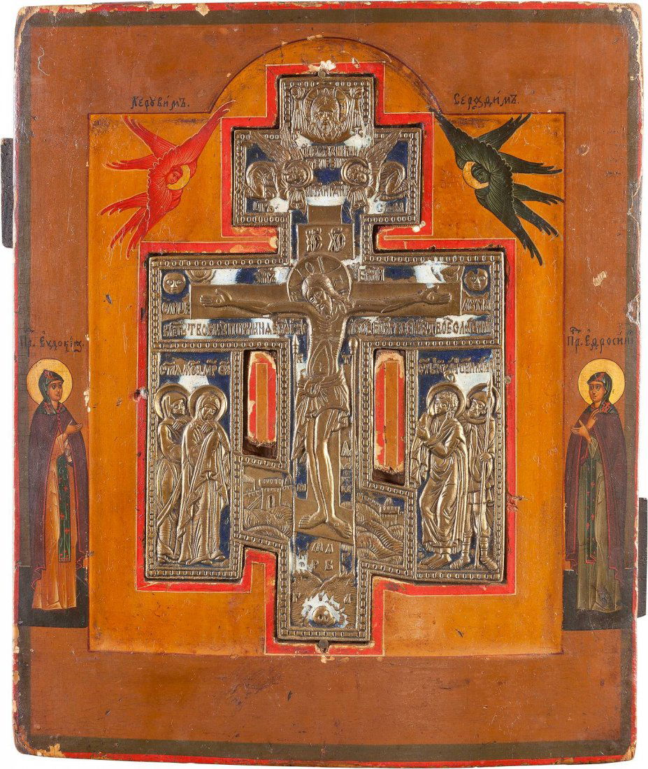 A BRASS ICON SHOWING THE CRUCIFIXION INSET INTO A PANEL: A BRASS ICON SHOWING THE CRUCIFIXION INSET INTO A PANEL Russian, late 19th century Tempera on wood panel with kovcheg. The central part inset with a blue and white enameled brass crucifixion flanked b