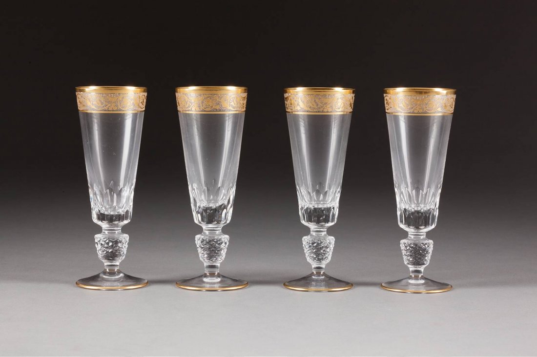 SATZ VON VIER SEKTFLÖTEN Wohl Frankreich, 20. Jh.: SATZ VON VIER SEKTFLÖTEN Wohl Frankreich, 20. Jh. Farbloses Glas, geschliffen. Umlaufender floraler Ätzfries mit Goldstaffage. H. 17 cm. In der Art von St. Louis 'Thistle Gold'. Min. ber.