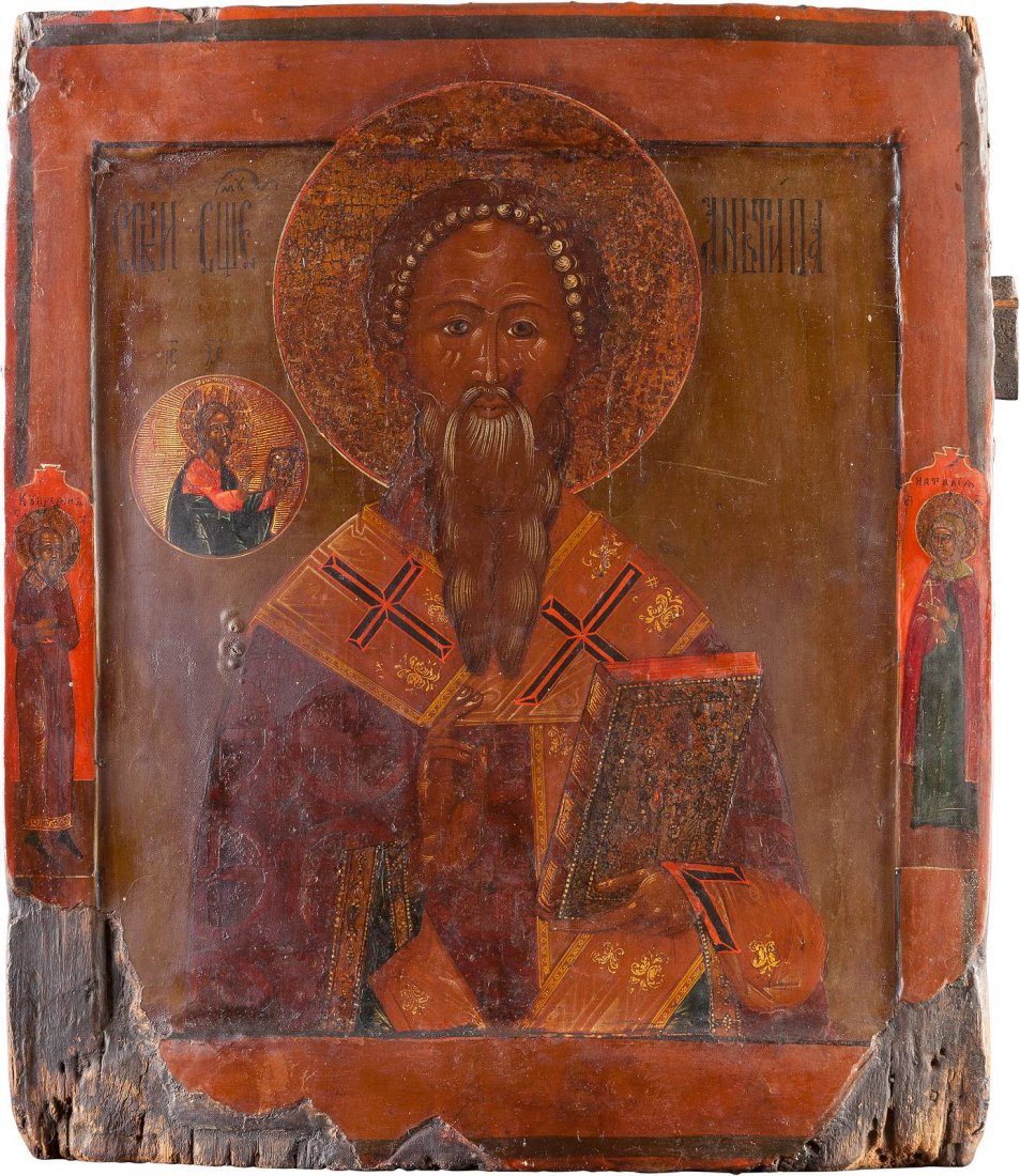 AN ICON SHOWING ST. ANTIPY Russian, circa 1800 Egg: AN ICON SHOWING ST. ANTIPY Russian, circa 1800 Egg tempera on wood panel with kovcheg. The saint depicted blessing and displaying the Gospel book. Two family saints on the borders. Losses to the borde