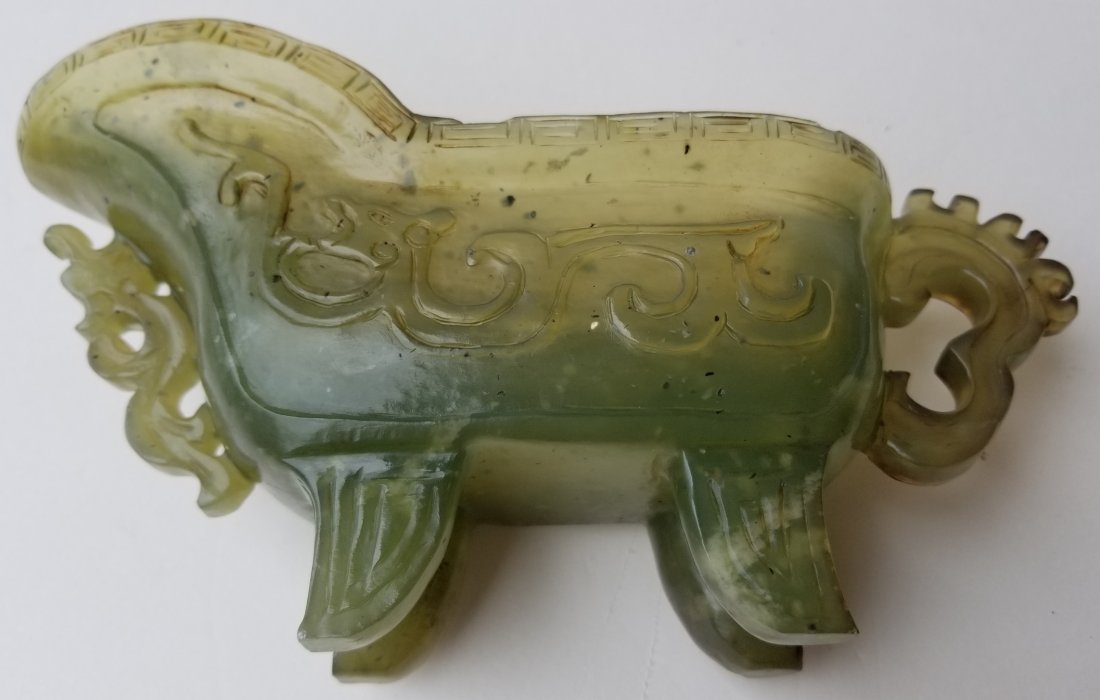 Chinese Archaic Form Carved Jade Beaker: Chinese Archaic Form Carved Jade Beaker Jade, serpentine or stone, Qing or Republic era, handled, footed and reticulated wine pitcher. 4.25 x 8 x 2.25 inches. ONLINE ONLY EVENT! NO RESERVES ABOVE STAR