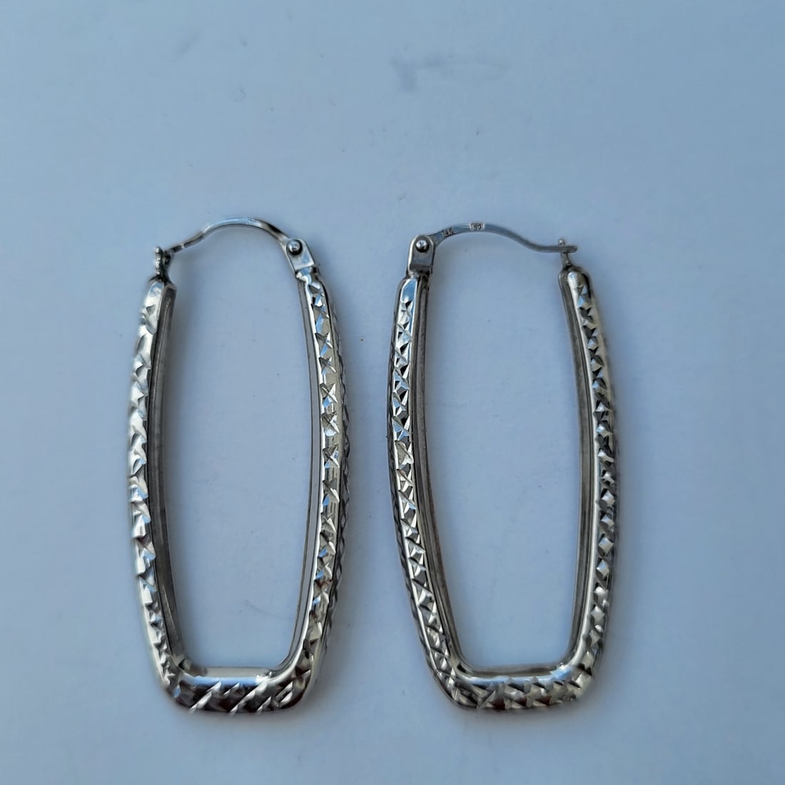 Modern Ladies Textured 14K White Gold U-Shape Hoop Earrings 1.4g 0.90dwt: Modern Ladies Textured 14K White Gold U-Shape Hoop Earrings 1.4g 0.90dwt. Weighs 1.4 grams and measures approx. 1.25 inches long. Marked 14K with a working hinge closure. RSIShipping: LiveAuctioneers