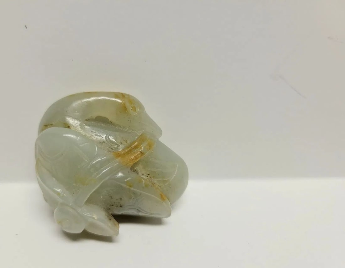 Klarich Collection 18C Chinese Jade Duck Carving Celadon Russet Skin Lotus: Klarich Collection 18C Chinese Jade Duck Carving Celadon Russet Skin Lotus. 1.5 x 1.75 x 1 inch, duckholds lotus blossom stem in mouth and sits atop a lotus blossom, with Manheim Galleries New Orleans