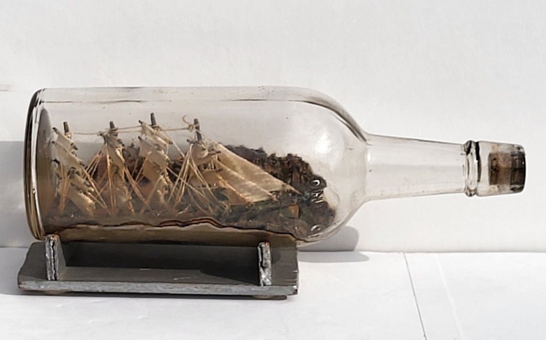 Folk Art Early 20C Ship In A Bottle Mariner Barque With Stand: Folk Art Early 20C Ship In A Bottle Mariner Barque With Stand, bottle 11.125 X 2.5 inches diameter, stand 1.5 X 6.5 X 2.875 inches, Provenance: Florida Gulf Coast estate, name withheld. RSI Shipping: 