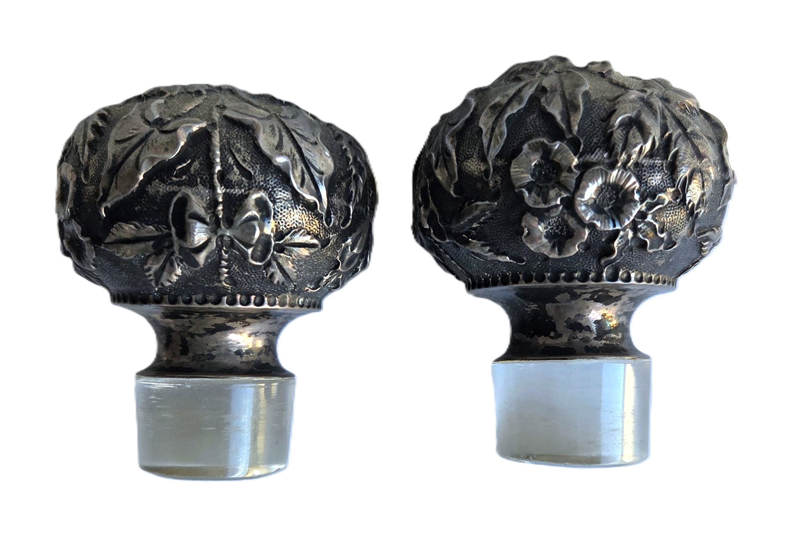 Great Pair Art Nouveau Silver Repousse Glass Bottle Stoppers: Great Pair Art Nouveau Silver Repousse Glass Bottle Stoppers. Unsure of metal content but likely sterling. Each measures 2.25 X 1.75 inches. Provenance: Property of a Florida Gulf Coast funeral indust