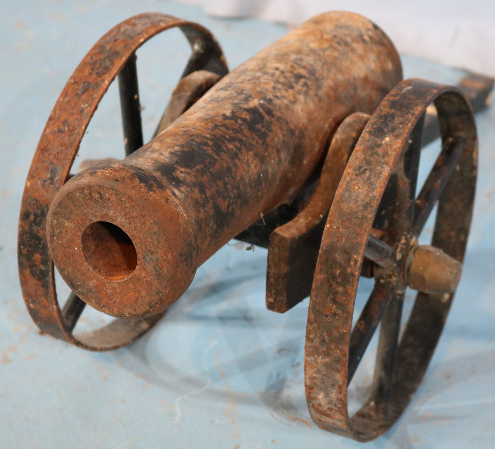 Small cast iron ships cannon on wheels: Small cast iron ships cannon on wheels, very old, 10 in. T, 14 in. L.