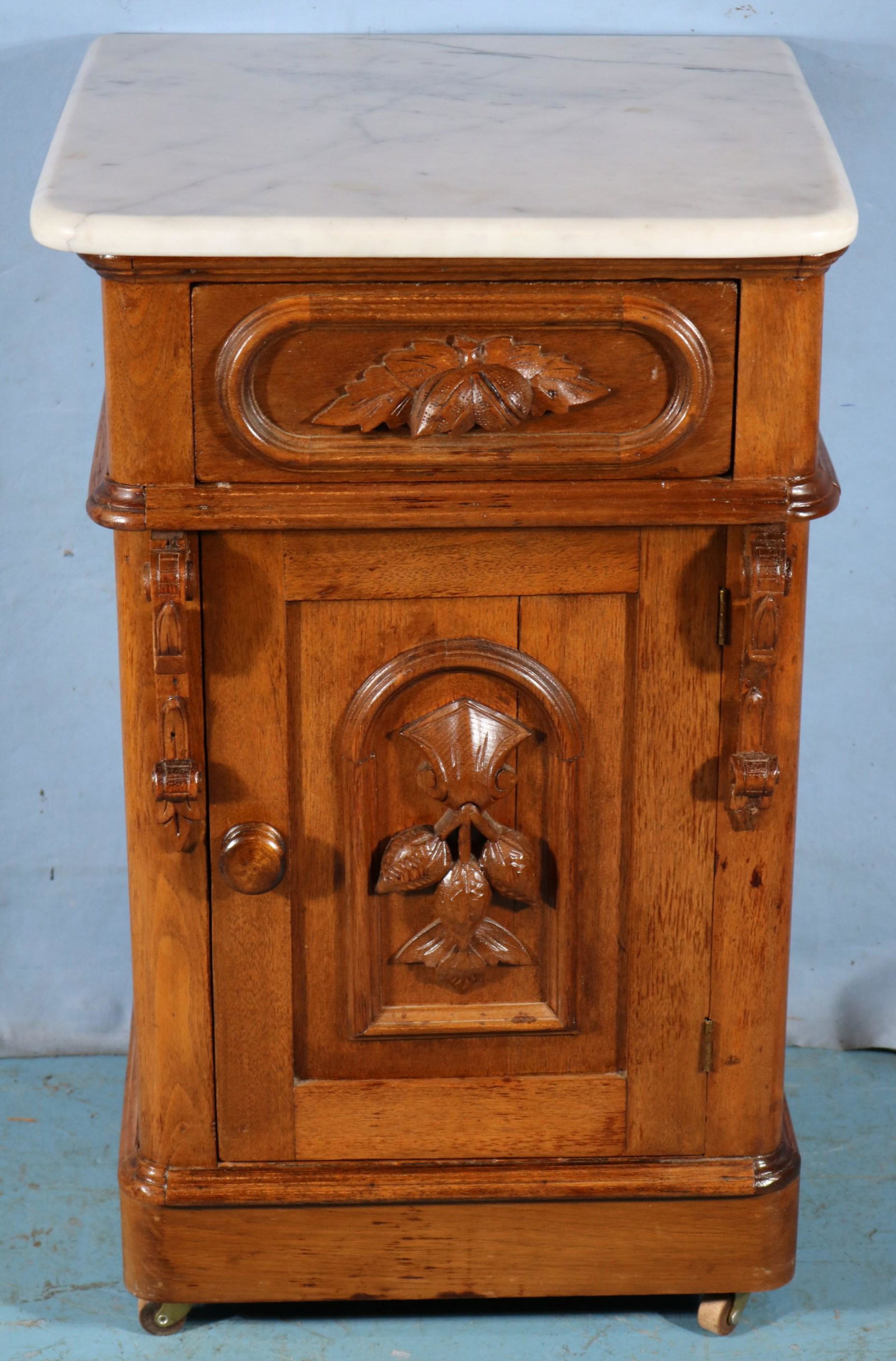 Walnut Victorian half commode: Walnut Victorian half commode with fruit carved on door, 29 in. T, 17 in. Sq.