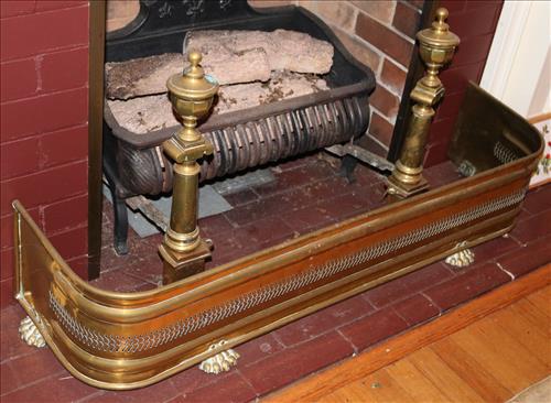 Brass andirons and fire place fender: Brass andirons and fire place fender. 9 in. T, 42.5 in. L, 11.5 in. D.