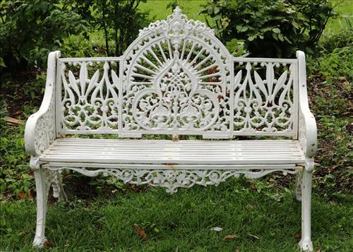 Cast iron love seat with iron slat seat: Cast iron love seat with iron slat seat, 36.5 in. T, 47 in. L, 16 in. D.