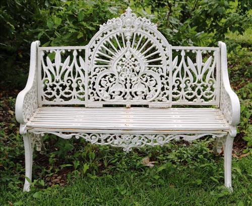 Cast iron love seat with iron slat seat: Cast iron love seat with iron slat seat, 36.5 in. T, 47 in. L, 16 in. D.