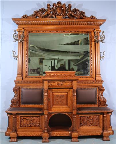 Monumental American Oak HallTree: Hall tree with Pierced Carved Cupid Crest and Dolphin Supports, One of a Kind Double Lift Seat Bench with Locking Door and Drawer Central Cabinet, H. 8 ft. , W. 5 ft. 10 in.