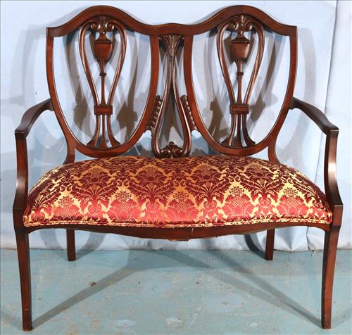 Mahogany two seater love seat: Mahogany two seater love seat, new red and gold silk upholstery in mint condition, 40 in. T, 42 in. W, 19 in. D.