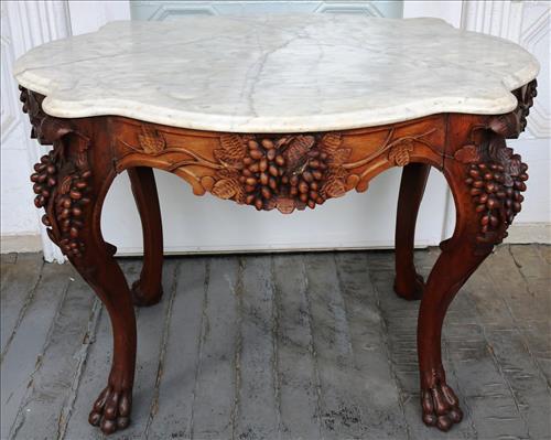Walnut turtle top parlor table with marble top: Walnut turtle top parlor table with marble top and heavily carved with grapes, 28 in. T, 40 in. L, 30 in. D.