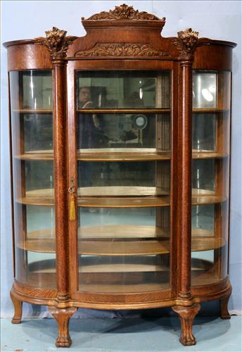 Quarter sawn oak china cabinet with 4 shelves: Quarter sawn oak china cabinet with 4 shelves, curved glass front and carved lions heads, 76 in. T, 56 in. W, 19 in. D.
