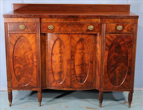 Flamed mahogany Federal sideboard with oval panels: Flamed mahogany Federal sideboard with oval panels, mortise back and original brass coasters, 47 in. T, 59 in. W, 22 in. D.