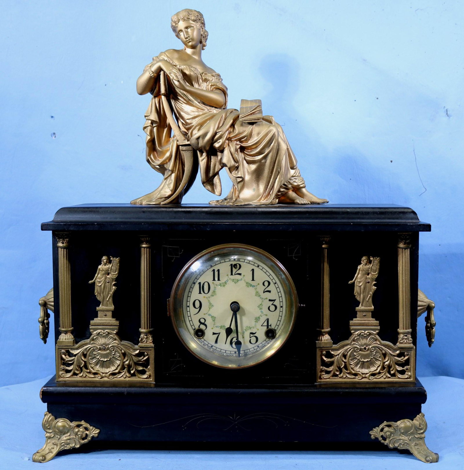 Sessions ebonized wood mantle clock: Sessions ebonized wood mantle clock with women on top and pendulum, 40.5 in. T, 17 in. W, 5.5 in. D.