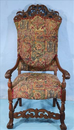 Mahogany fire side arm chair with carved crown: Mahogany fire side arm chair with carved crown and tapestry upholstery, 53 in. T, 26 in. W, 27 in. D.
