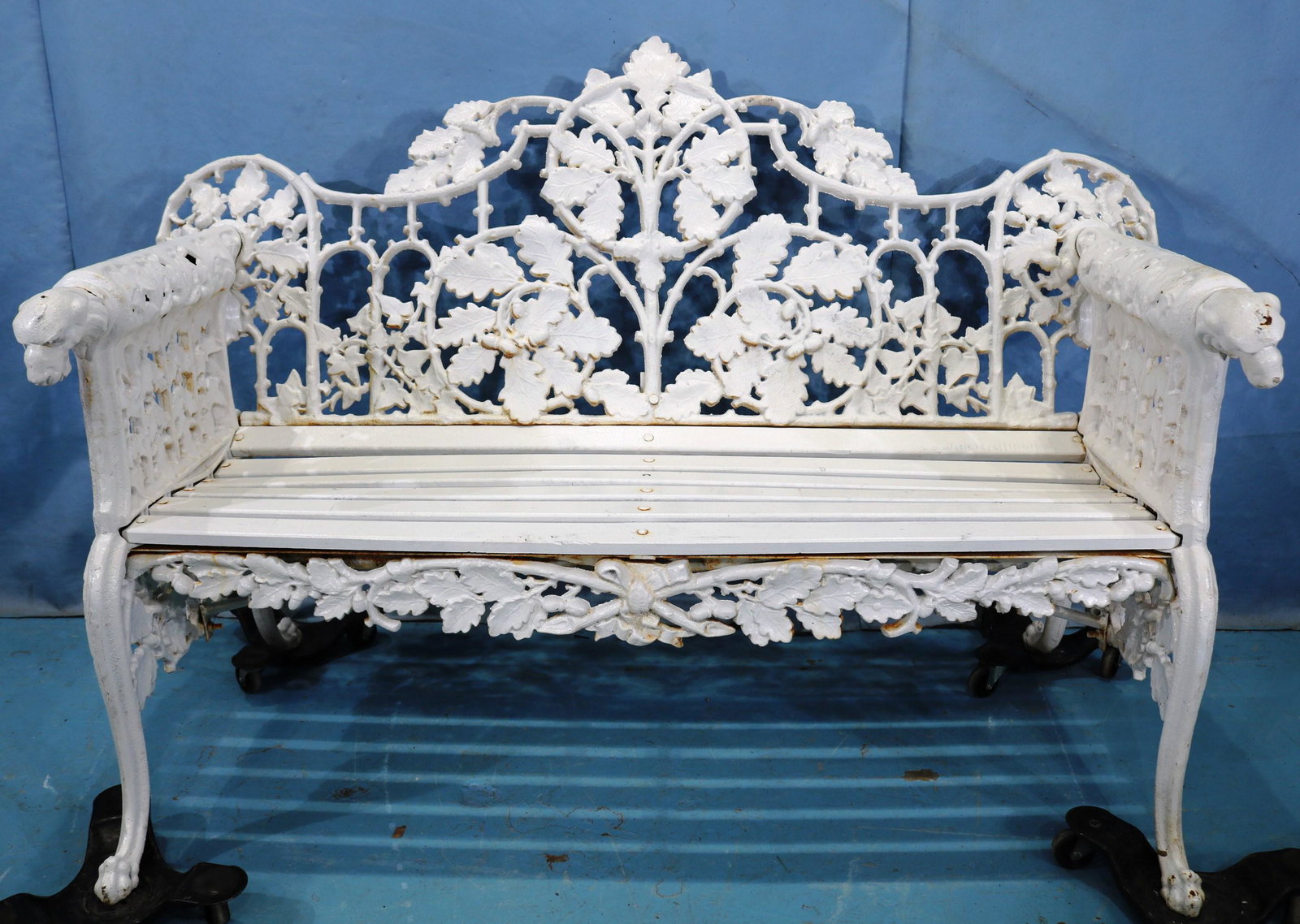 Cast iron garden bench with dog head on round arms: Cast iron garden bench with dog head on round arms, 38 in. T, 67 in. W, 20 in. D.