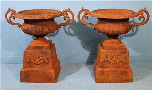 Pair of rust cast iron garden urns on stands with handles: Pair of cast iron unpainted garden urns on stands with handles, 29 in. T, 28 in. W.