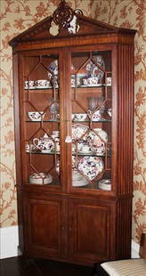 Mahogany corner cupboard with bracket feet and arch crown: Mahogany corner cupboard with bracket feet, broken arch crown, 3 glass shelves and original key. Natchez Henredon Collection, 92 in. T, 45 in. W, 19 in. D.