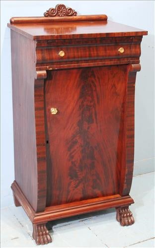 Flame mahogany Empire music cabinet with claw feet: Flame mahogany Empire music cabinet with 1 door, 1 drawer, claw feet and glass pulls, 44 in. T, 22 in. W, 15 in. D.