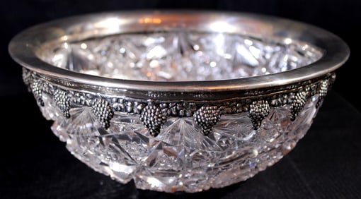 Heavy brilliant cut glass bowl has sterling rim with grapes all around