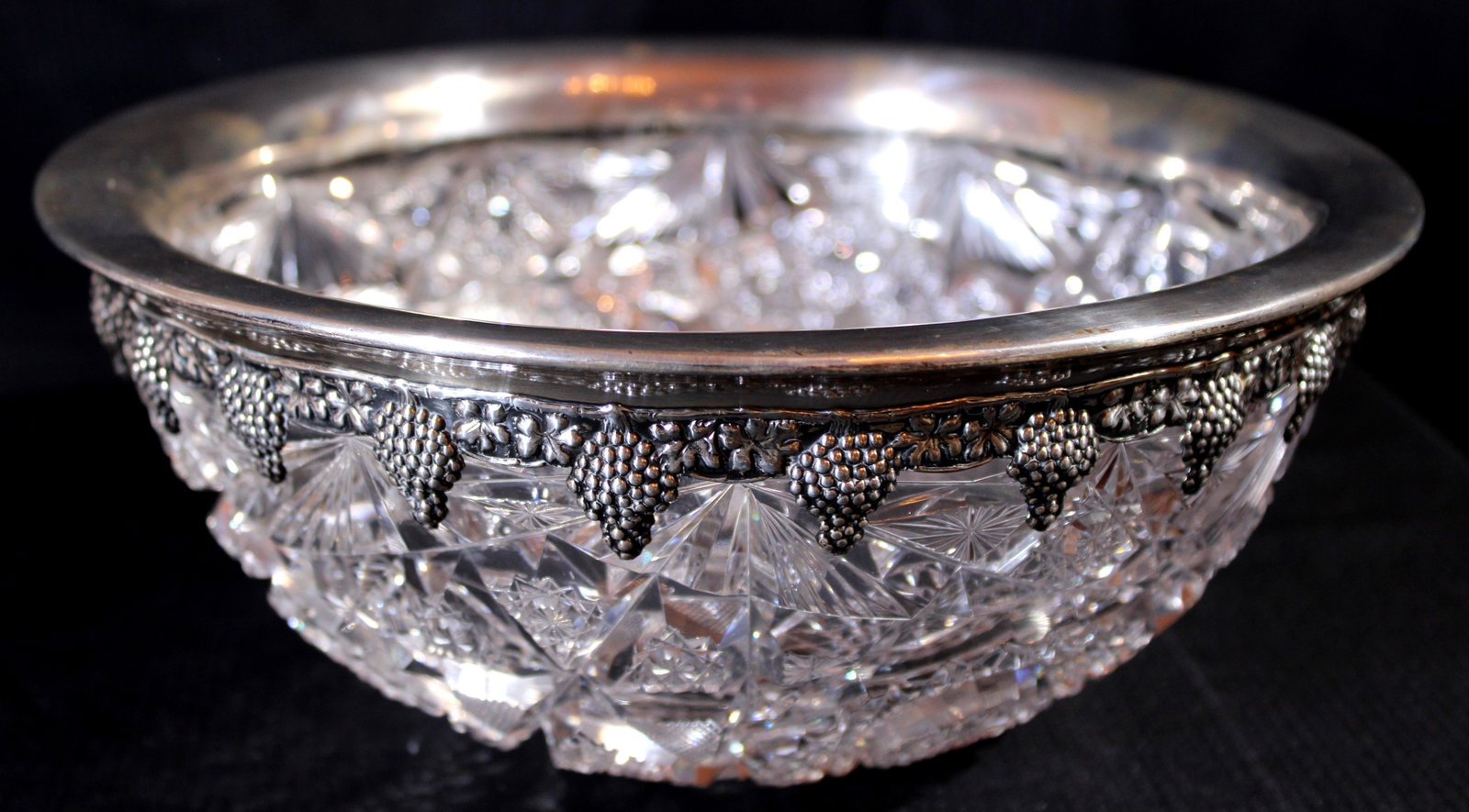 Heavy brilliant cut glass bowl has sterling rim with grapes all around: Heavy brilliant cut glass bowl has sterling rim with grapes all the way around, good condition