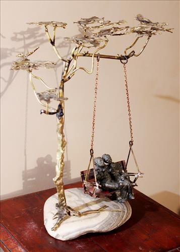 Bronze of elderly couple in swing, mounted on rock, 15 in. T.: Bronze of elderly couple in swing, mounted on rock, 15 in. T, 16 in. W.
