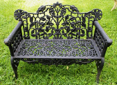 Heavy cast iron garden love seat painted black with ram heads
