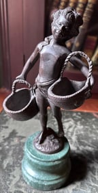 Bronze of girl with baskets on marble base, signed