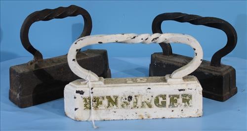 Group of 3 Smoothing Irons or Door Stops: Set of Three Antique Smoothing Irons, or sad irons, including two cast iron flat irons with integral handles and one charming white-painted iron labeled "EININGER" in worn gold lettering. Each piece s