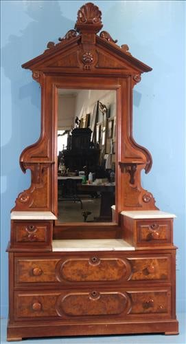 Victorian Walnut & Burl Marble-Top Dresser with Ornate Crest: This grand walnut and burl dresser stands an impressive 91 inches tall and showcases the period’s signature opulence. The piece features an ornate carved crest with a central shell motif, flanked by