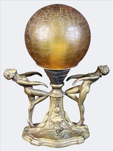 Art Deco Figural Lamp with Crackle Glass Globe: Early 20th century art deco figural lamp, the spelter base cast with two nude female figured supporting a central stem that rises to a crackle glass amber globe. The sculptural form and sensuous styli