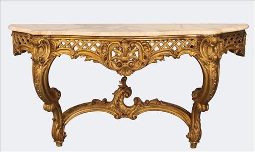 19th Century Giltwood Marble-Top Console Table: Magnificent 19th century giltwood console table, richly carved in the Rococo Revival taste with scrolling foliate and shell motifs, centered by a bold pierced cartouche. The original serpentine white