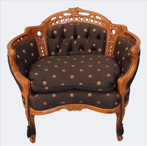 Victorian Carved Corner Chair: Unusual Victorian corner chair with elaborately carved and pierced crest rail featuring ehart and scroll motifs, rising over a deep tufted upholstered back and seat in black fabric with gilt medallion
