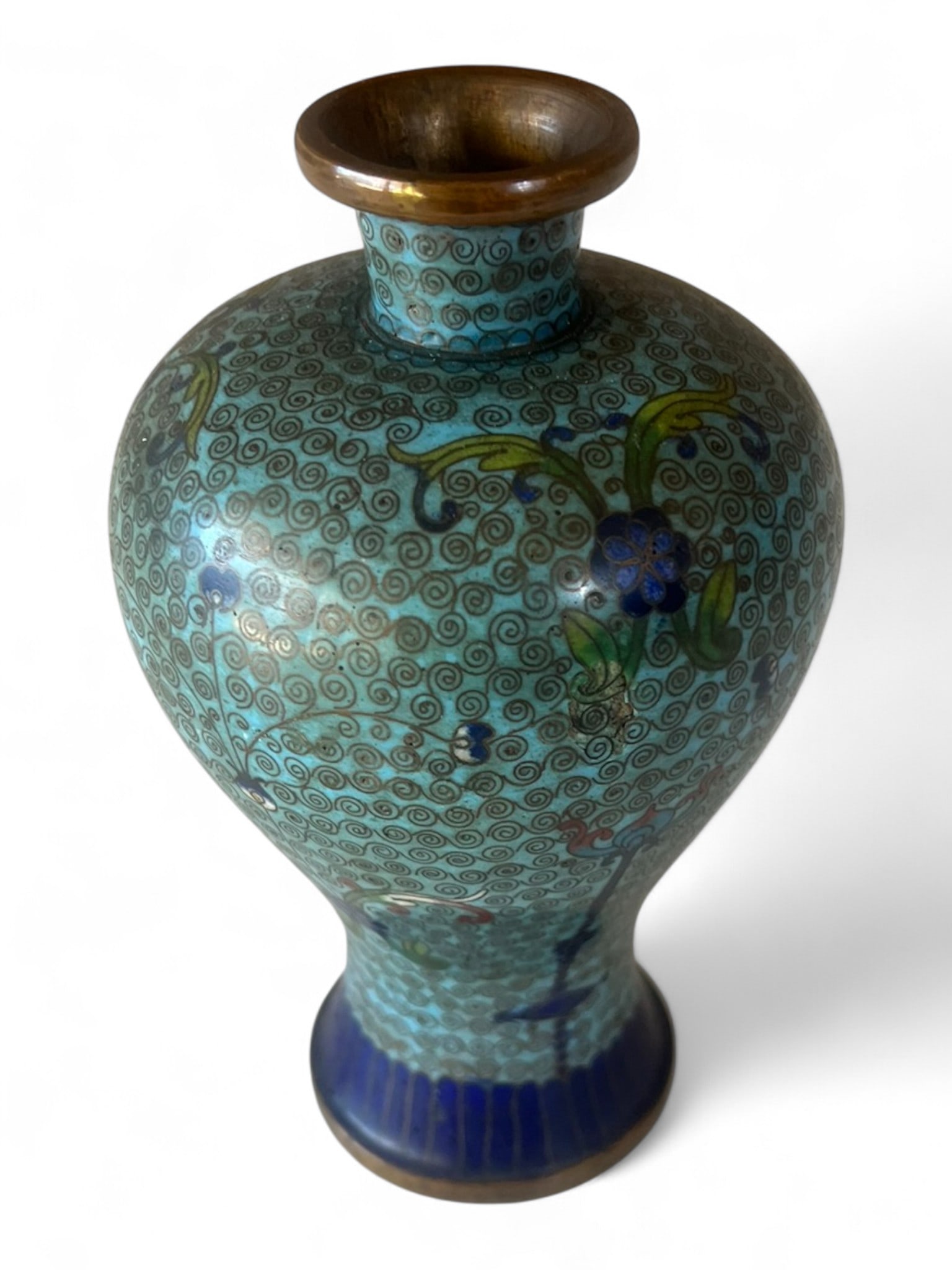 Small Chinese Cloisonné Vase: Delicate Chinese cloisonné enamel vase of baluster form, finely worked with scrolling floral and foliate designs in shades of turquoise, cobalt, and green, against a light blue ground with intricate