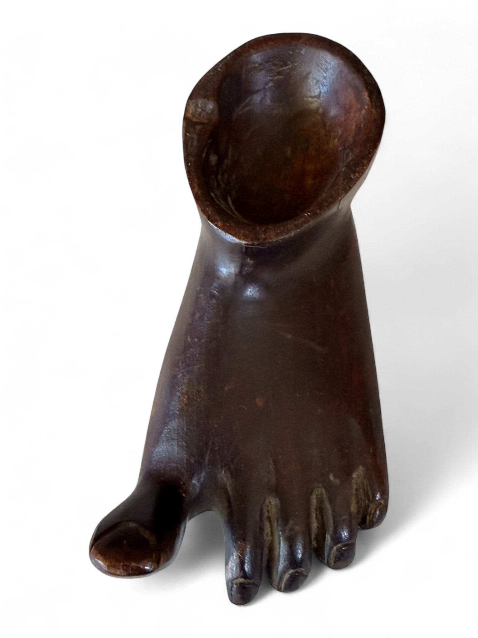 Carved Hardwood Foot Form Bowl, West African, Mid-20th Century: An evocative hand-carved hardwood vessel fashioned in the shape of a human foot, the upper portion hollowed to form a small bowl or libation cup. The anatomical detail is skillfully modeled, from the 