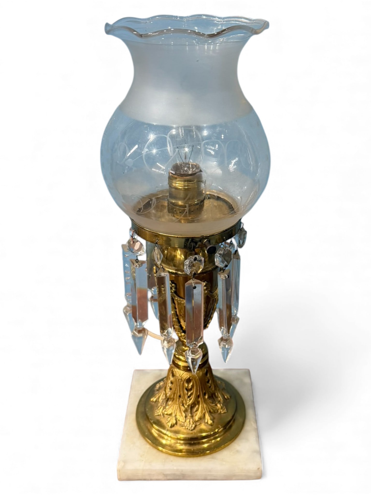 Gilt Metal and Crystal Lustre Table Lamp with Glass Shade, early 20th century: Decorative table lamp featuring a gilt metal columnar stem with classical acanthus and foliate detailing, fitted with a ring of hanging faceted crystal prisms terminating in pointed drops. The lamp is