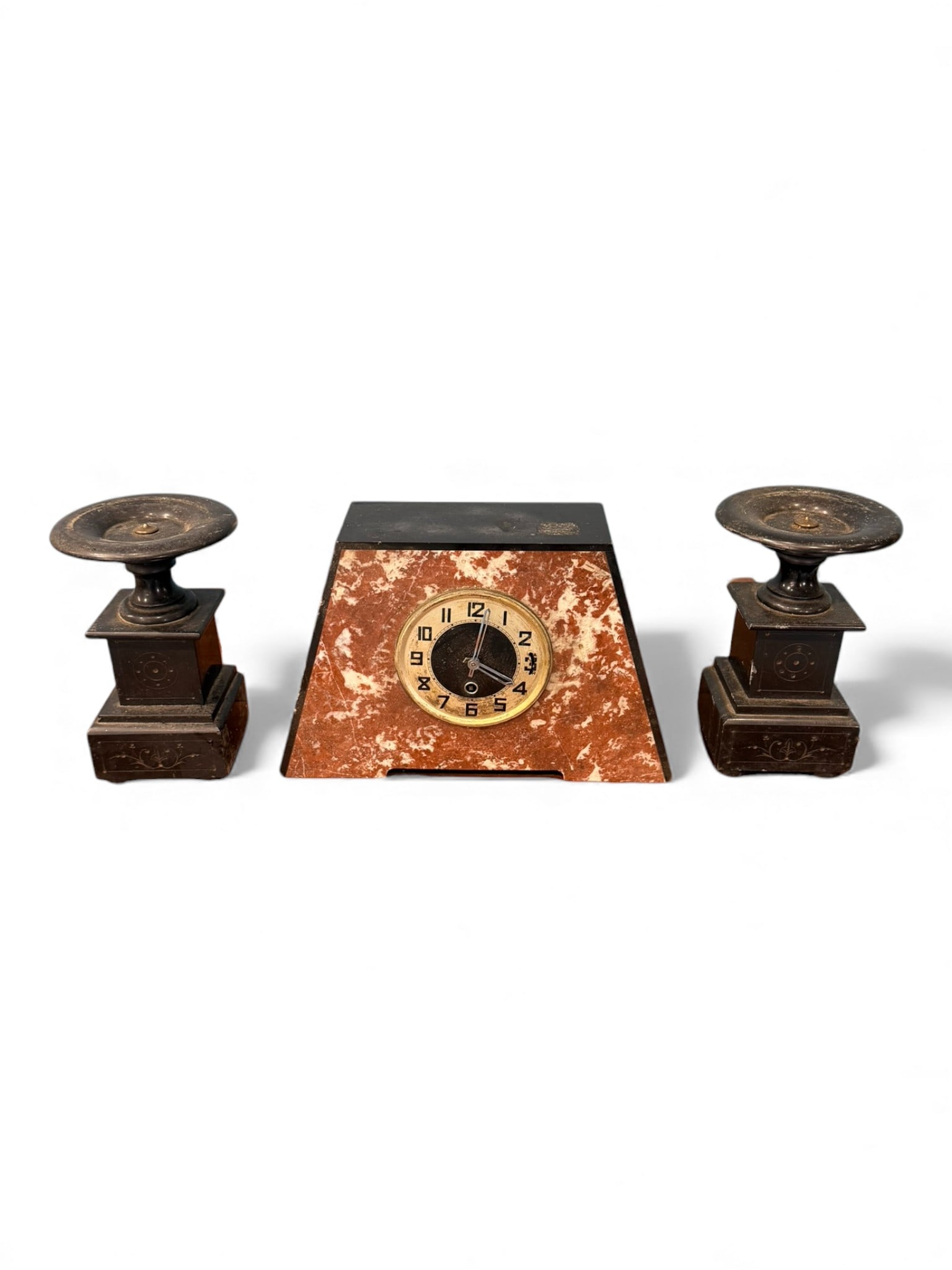 Art Deco Marble Mantel Clock with Pair of Metal Candlesticks, early 20th century: Three-piece Art Deco mantel garniture comprising a trapezoidal marble clock flanked by a matching pair of metal candlesticks. The clock features a red and white mottled marble case with black stepped