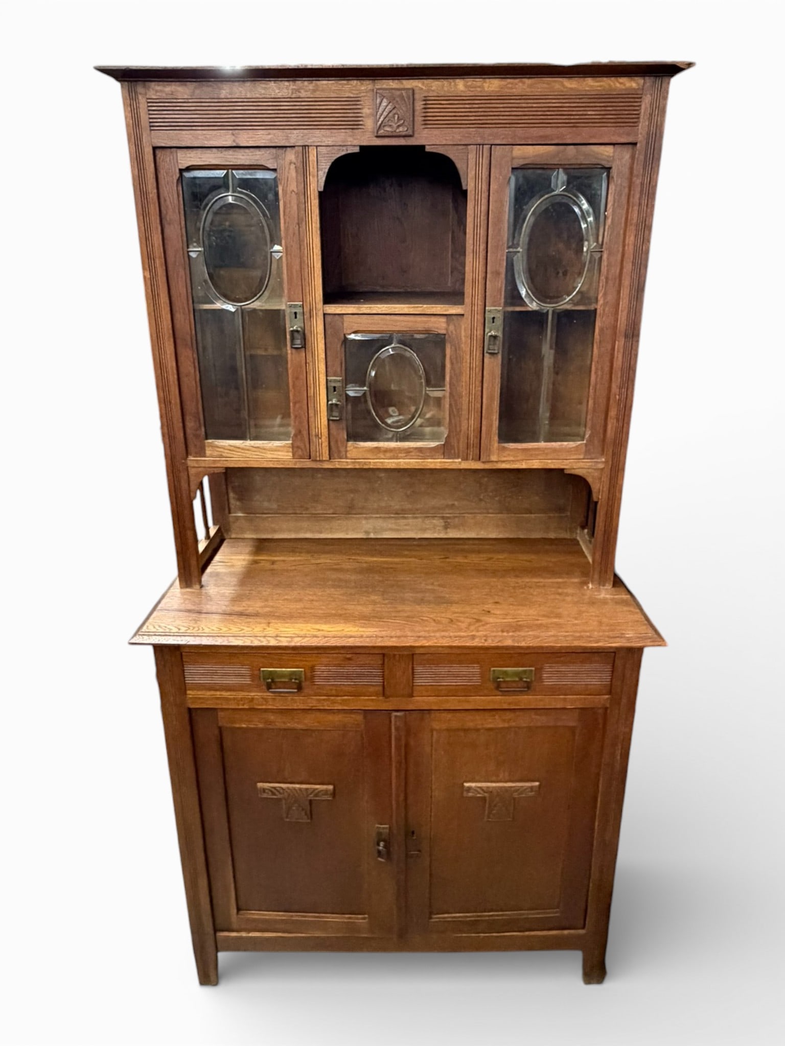 Arts & Crafts Oak Buffet and Hutch with Leaded Glass Doors, Early 20th Century: Early 20th century Arts & Crafts oak buffet and hutch, constructed in oak with a warm medium-brown finish. The upper hutch section is fitted with leaded glass doors featuring oval panes, flanking a ce