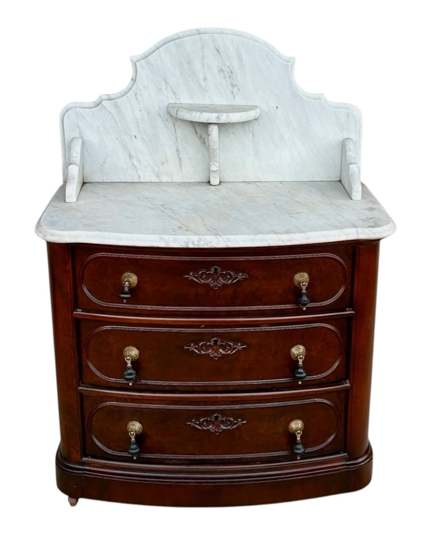 Victorian Walnut Marble-Top Washstand with Oversized Backsplash: A handsome Victorian walnut washstand featuring a boldly scaled white marble top and matching shaped marble backsplash. The case presents a gently bowed front fitted with three graduated drawers, each