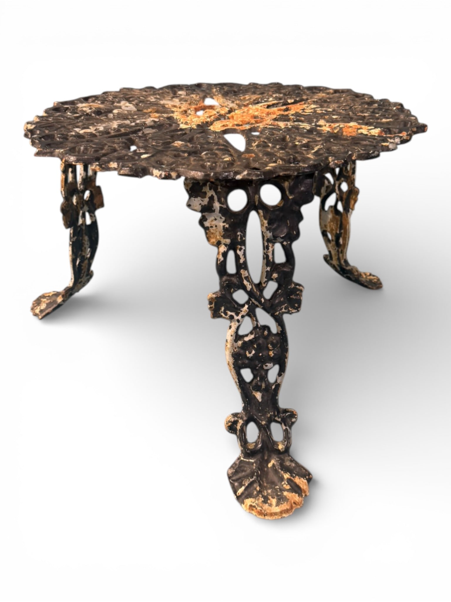 Black Cast Iron Garden Table: A charming Victorian-style cast iron garden table featuring an intricately pierced grapevine and foliate pattern top with radiating segments centered by a stylized floral medallion. The circular top r