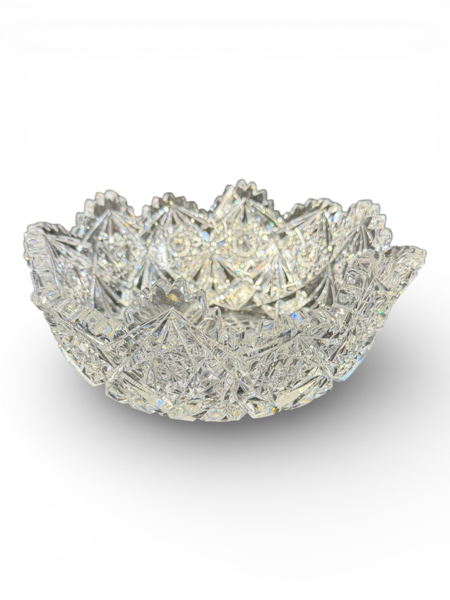 American Brilliant Cut Glass Bowl: American Brilliant cut glass bowl of round form with pronounced scalloped rim and deeply cut geometric decoration. The body displays repeating hobstars framed by triangular prism cutting and fine cros