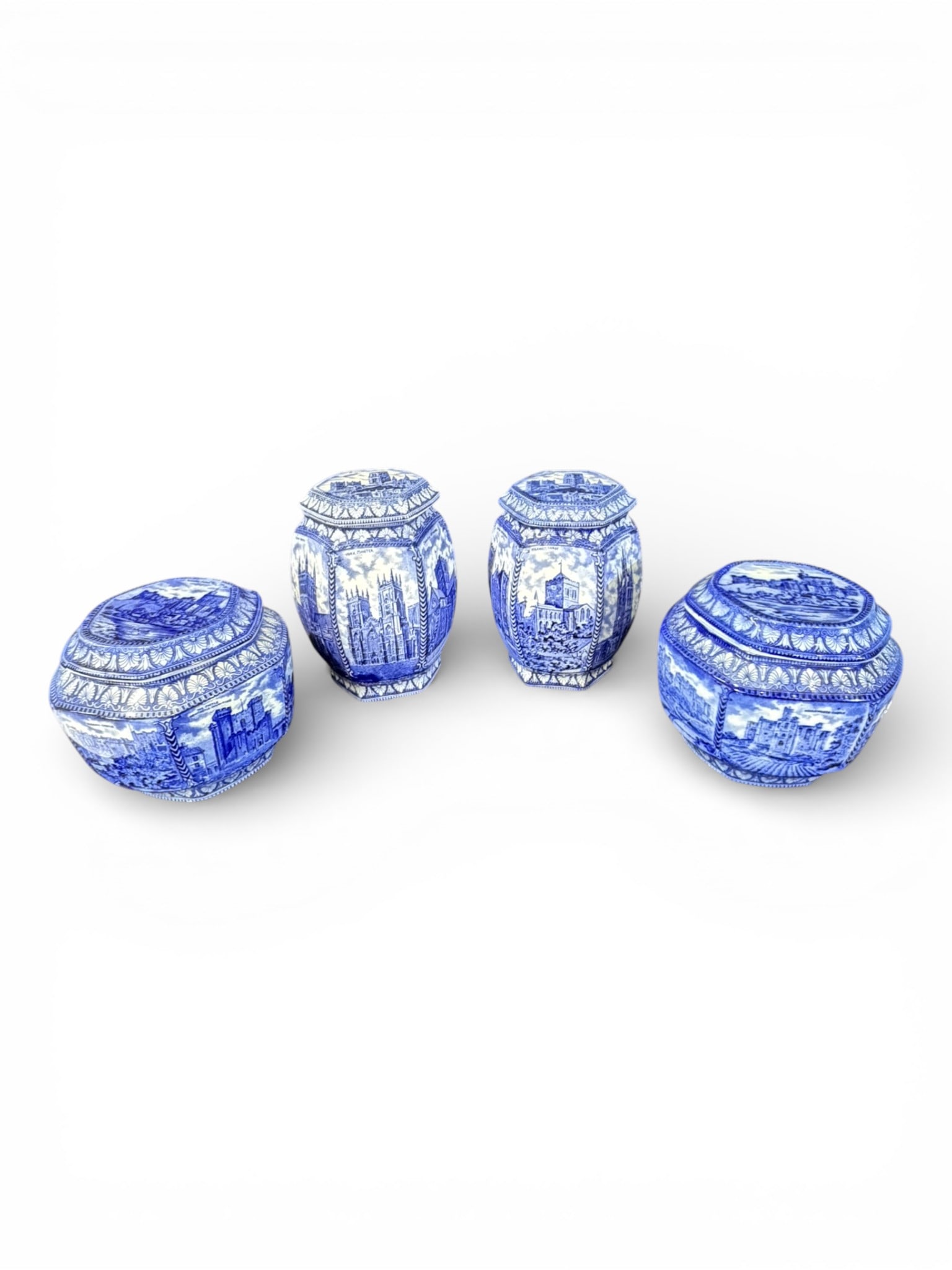Four-Piece Flow Blue Scenic Canister Set: A decorative four-piece English flow blue canister set, late 19th to early 20th century, each of faceted form with fitted lids. Decorated throughout with transfer-printed scenic views of English