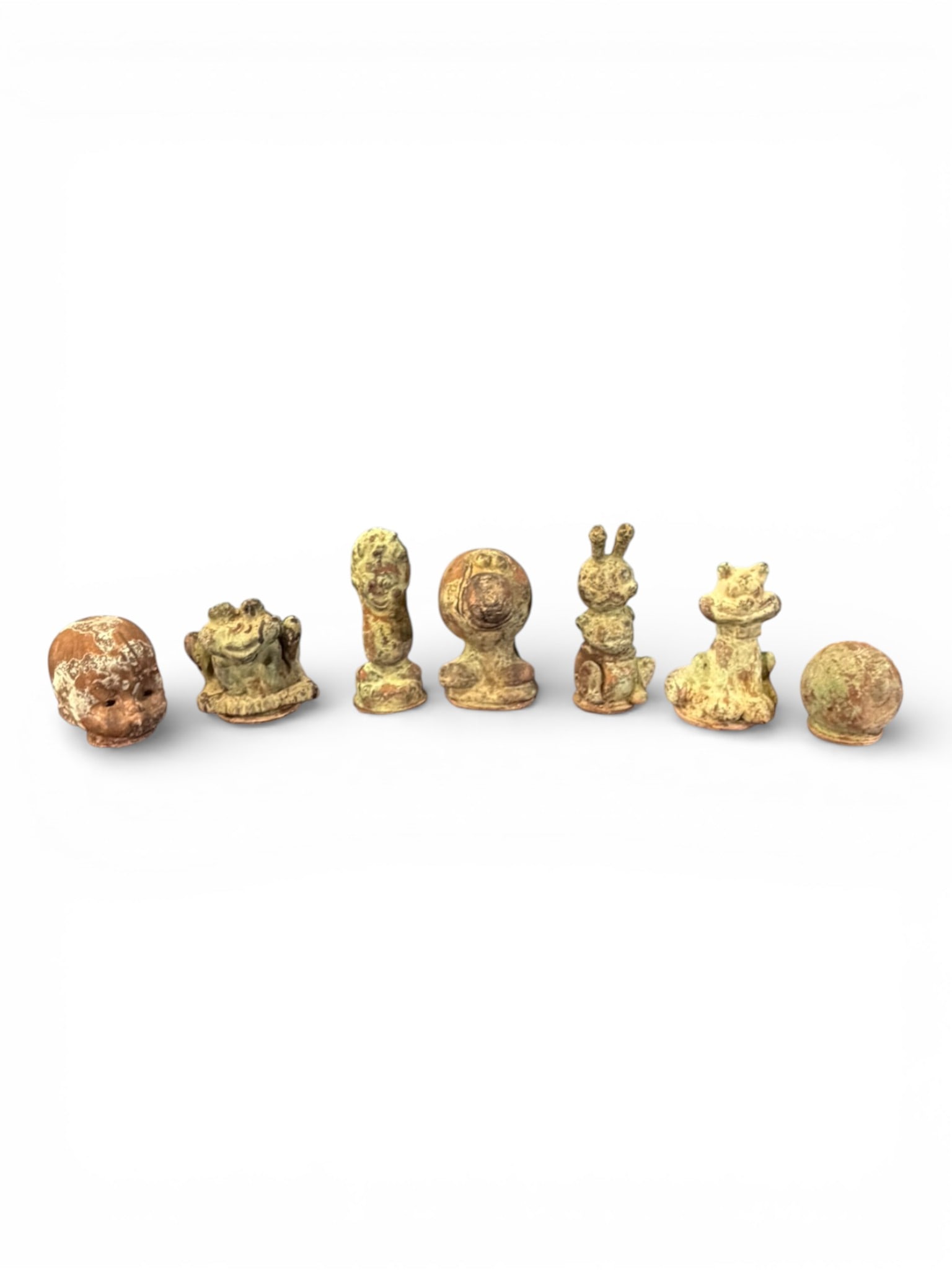 Group of Seven Asian Cast Metal Figures: Decorative group of seven small Asian cast metal figures, each rendered in whimsical and figural form including human and animal subjects. The assortment features a variety of characterful