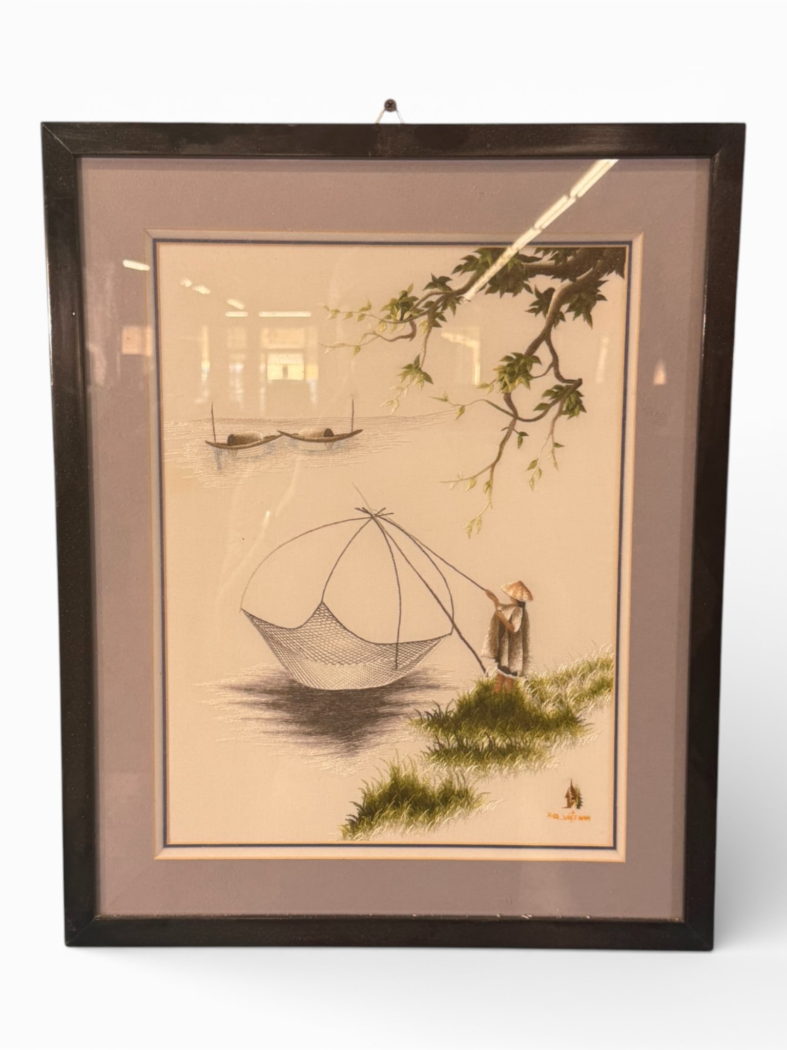 Vietnamese Hand Embroidered Silk Picture, “Fishing Net,?? XQ Vietnam, Contemporary: A finely executed Vietnamese hand-embroidered silk picture depicting a solitary fisherman casting a traditional net along a quiet riverbank, with distant boats and overhanging foliage creating a
